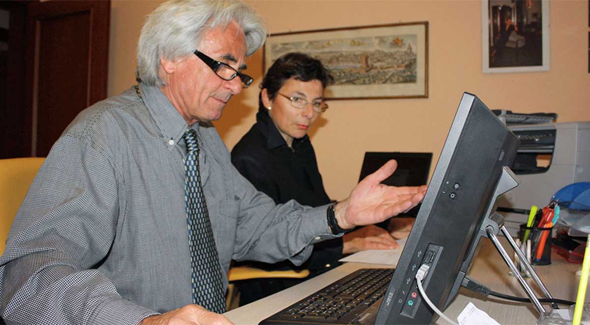 Two ItalianLaw.net experts using computers to prepare notarized documents concerning inheritance for filings in Italy.